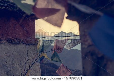 Mountain sunset thorugh a windows of buddhist flags. Dhaulagiri above Muktinath.