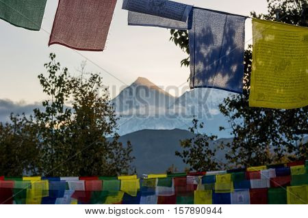 Dhaulagiri at sunset. View through buddhist praying flags.