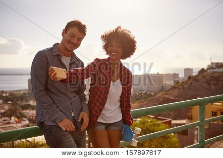 Millennial Couple Taking Selfies On Bridge