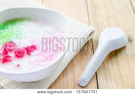 Tub Tim Krob ,Stuffed Water Chestnut in Syrup and Coconut Milk on wood table thailand dessert.