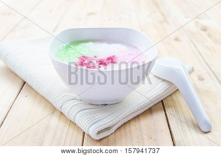 Tub Tim Krob ,Stuffed Water Chestnut in Syrup and Coconut Milk on wood table thailand dessert.