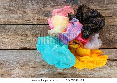 Different plastic bags on old wooden background. Top view.