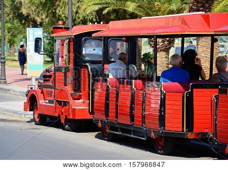 RETHYMNO, CRETE - SEPTEMBER 15, 2016 - Tourists aboard a red land train along the promenade Rethymno Crete Greece Europe, September 15, 2016.