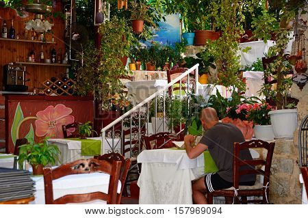 RETHYMNO, CRETE - SEPTEMBER 15, 2016 - Man sitting in a restaurant in the old town Rethymno Crete Greece Europe, September 15, 2016.
