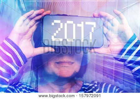 Woman wearing virtual reality headset with number 2017 happy new year