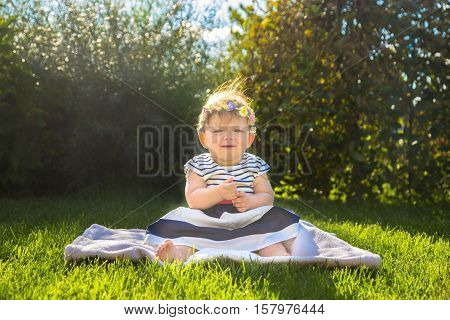 Beautiful baby girl on the green grass. Happy childhood