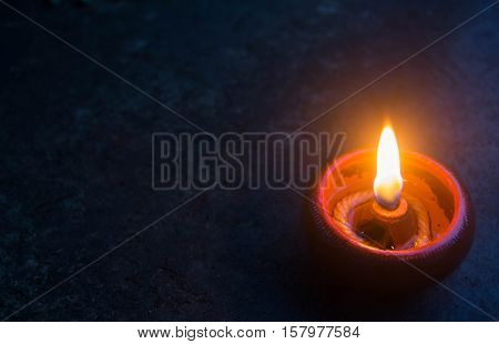Candle or beeswax light surrounding by dark nature