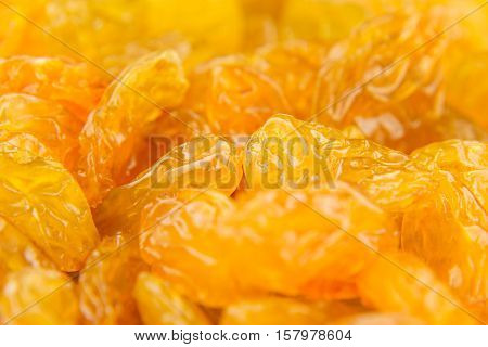 Raisins yellow closeup background. Heap of shiny golden yellow raisins dried fruit.