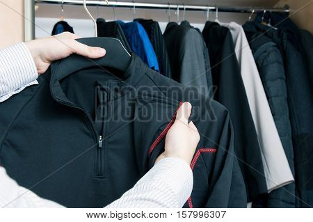 Man takes out thermoactive sweatshirt from the closet