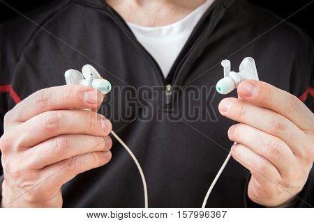 Runner assumes modern waterproof wireless headphones. Concept of technology in sport