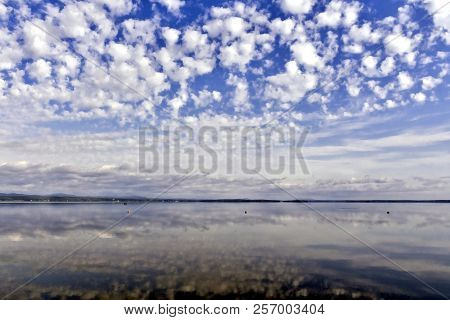 Bright Clouds Reflected In The Water, South Ural Lake Uvildy, In The Distance Are Seen The Ural Moun