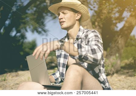Young Male Travel Graphic Designer Freelancer Working With Lapop On The Beach