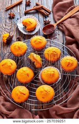 Freshly Baked Delicious Sweet Pumpkin Muffins  On A Round Stainless Steel Cake Cooling Rack On A Rus
