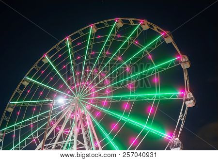 Carnival Ride Showing Spinning Ferris Wheel In Action- Long Exposure Shot.