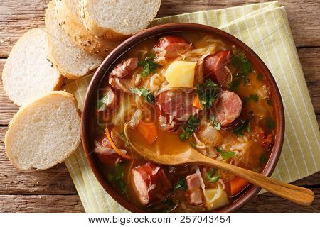 Delicious Soup Of Sauerkraut With Sausages And Vegetables Close-up In A Bowl. Horizontal Top View