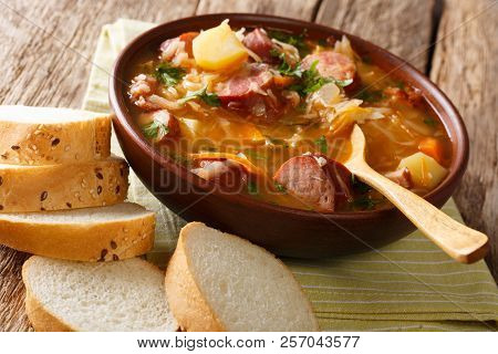 Homemade Spicy Soup Of Sauerkraut With Sausages And Vegetables Close-up In A Bowl. Horizontal