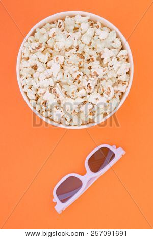 Paper Cup With Popcorn And 3d Glasses On Orange Background, Top View. Flat Lay. Copyspace