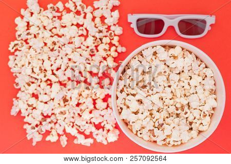 White 3d Glasses Paper Cup And Fresh Cheesy Popcorn On A Red Background, Top View, Copyspace. Cinema
