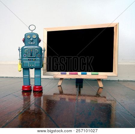 robot and a  blacboard on a wooden floor  with reflection 
