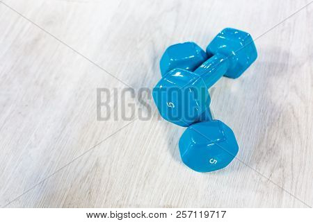 Blue Modern Dumbbells On A Wooden Floor