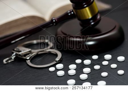 Judge's Gavel With Handcuffs, Drugs On Wooden Table