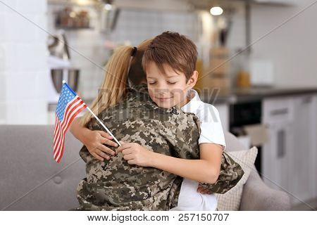 Woman In Military Uniform With Her Little Son At Home
