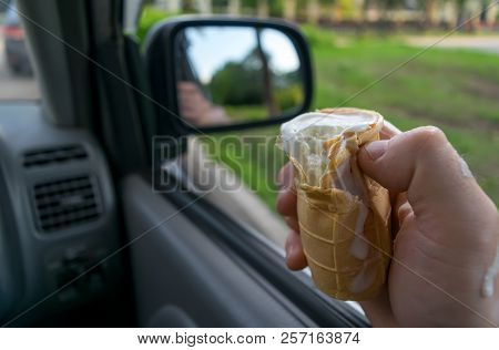 The Driver Holds The Ice Cream While Driving A Car