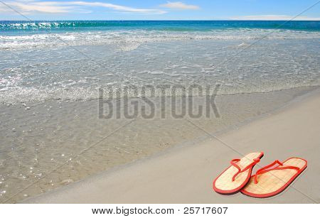 รองเท้าฟาง flipflop สีส้มบนหาดทะเลสวย