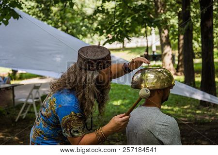 Moscow, Park On Krasnaya Presnya, August 05, 2018: A Man Makes A Massage With A Large Tibetan Singin