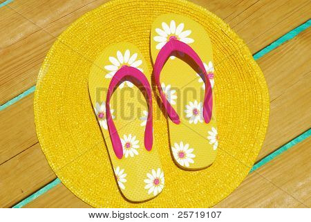 Flipflops สีเหลืองบนท่าเหนือน้ำทะเลสวย