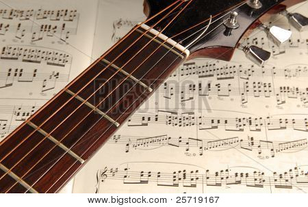 Akusztikus gitár nyakát és a tuning pegs kották háttérrel