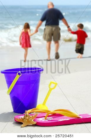 Ojciec i dzieci przy plaży wiadro, klapki i rozgwiazdy na plaży