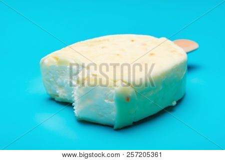 White Popsicle With Some Bites On Blue Background