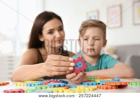 Young Woman And Little Boy With Autistic Disorder Playing At Home, Closeup