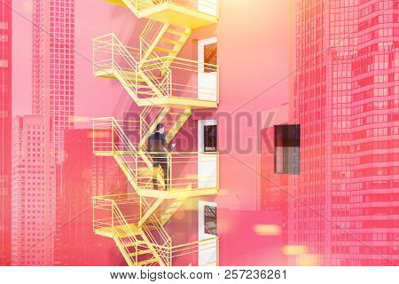 Busienssman With Smartphone Standing Of Yellow Emergency Exit Stairs Of A Red Building. Concept Of P
