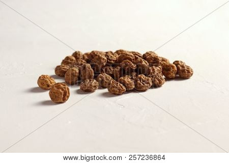 Isolated Tigernuts / Earth Almonds / Nutsedges On Slightly Structured White Surface