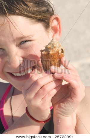 Young girl excited to find pretty seashell