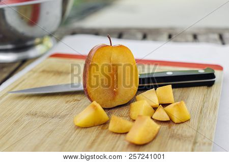 Face Of An Amigo Pluot Is Chopped And Chopped Pieces On A Cutting Board