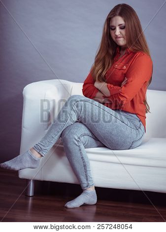 Angry, Pissed Off Young Woman. Attractive Female With Long Brown Hair Sitting On Sofa Being Mad And 