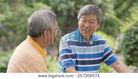 Asian Male old friends talking together at outdoor park