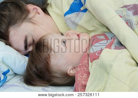 Little Baby Girl Wake Up In The Morning. Parent Tired Sleeping. Father Lying On Bed. Happy Family.