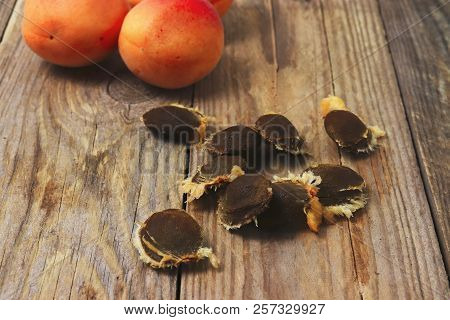 Apricots And Apricot Stones On Wooden Table