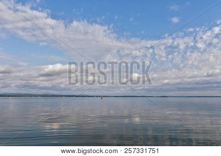 Bright Clouds Reflected In The Water, South Ural Lake Uvildy, In The Distance Are Seen The Ural Moun
