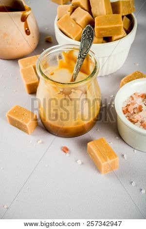 Salted Caramel Sauce With Fudge Candy, Fleur De Sel, Brown Cane Sugar, Grey Background Copy Space To