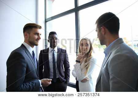 Young Modern Colleagues In Smart Casual Wear Having A Brainstorm Meeting While Standing In The Creat