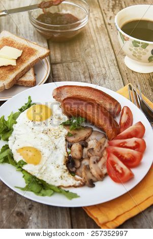 English Breakfast. Eggs, Sausages, Mushrooms, Tomatoes, Toast Bread. Eating Tasy Food Over Rustic Wo