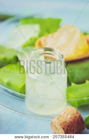 Aloe Vera Extract In A Small Bottle And Pieces On The Table. Selective Focus.