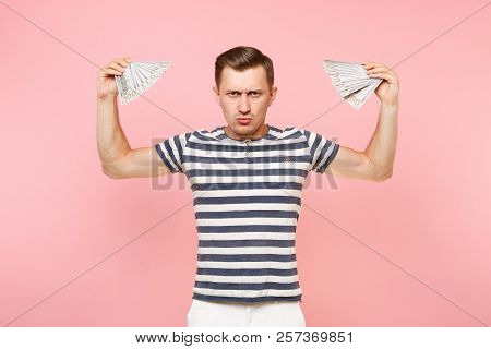 Portrait Of Smiling Excited Young Man In Striped T-shirt Holding Bundle Lots Of Dollars, Cash Money,