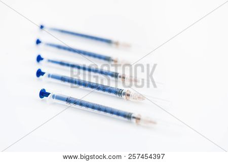 Closeup Of Five Disposable Insulin Syringes In Row Isolated On White Background, Medicine And Treatm