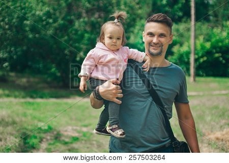 Family Portrait Of Father And Daughter: A Man Lifted A Girl Up. The Trust Business Partners